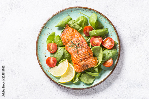 Canvas Print Baked salmon fish fillet with fresh salad top view.