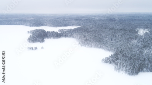 Aerial view of frozen lake and forest covered by snow. National park Helvetinjarvi in Finland at winter photo