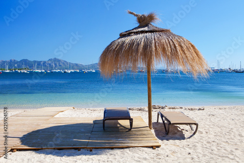 Chairs and umbrella on the beach in Port de Pollenca, Majorca, Spain photo