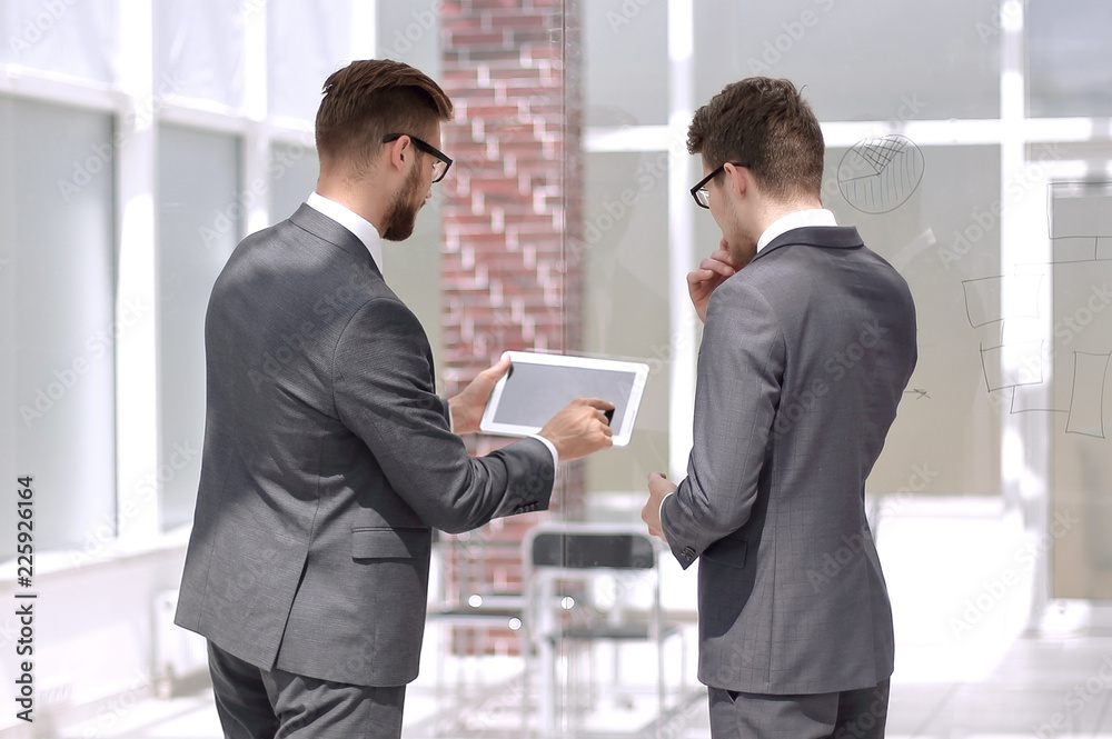 employees discuss information using a digital tablet. employees discuss information using a digital tablet.