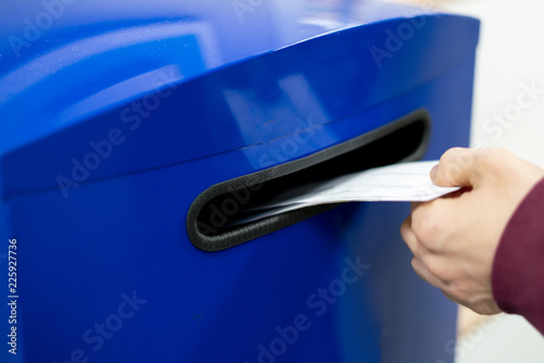 Canvas Print close up hand drop letter and documents in the blue postbox in post office mail