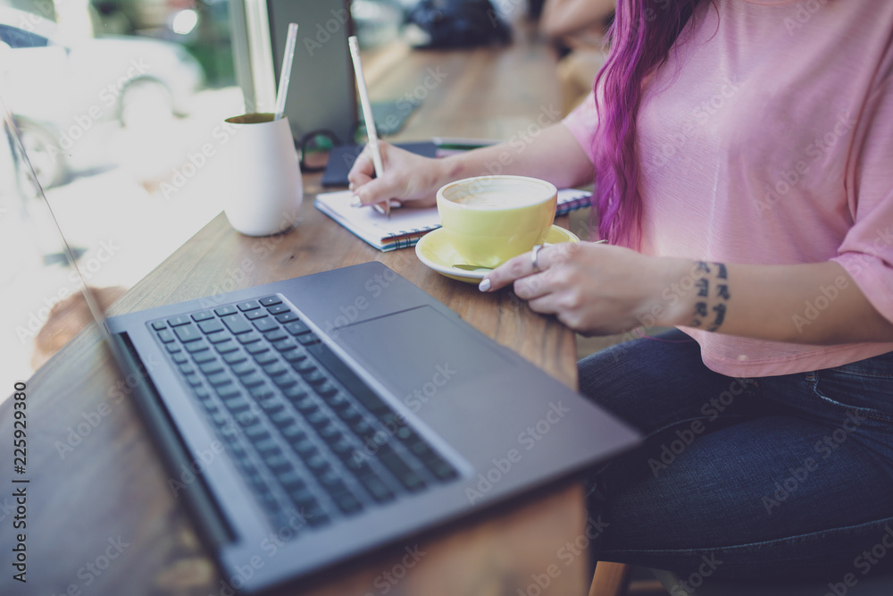 Woman typing on notebook with blank screen, sitting at wooden ta Woman typing on notebook with blank screen, sitting at wooden ta