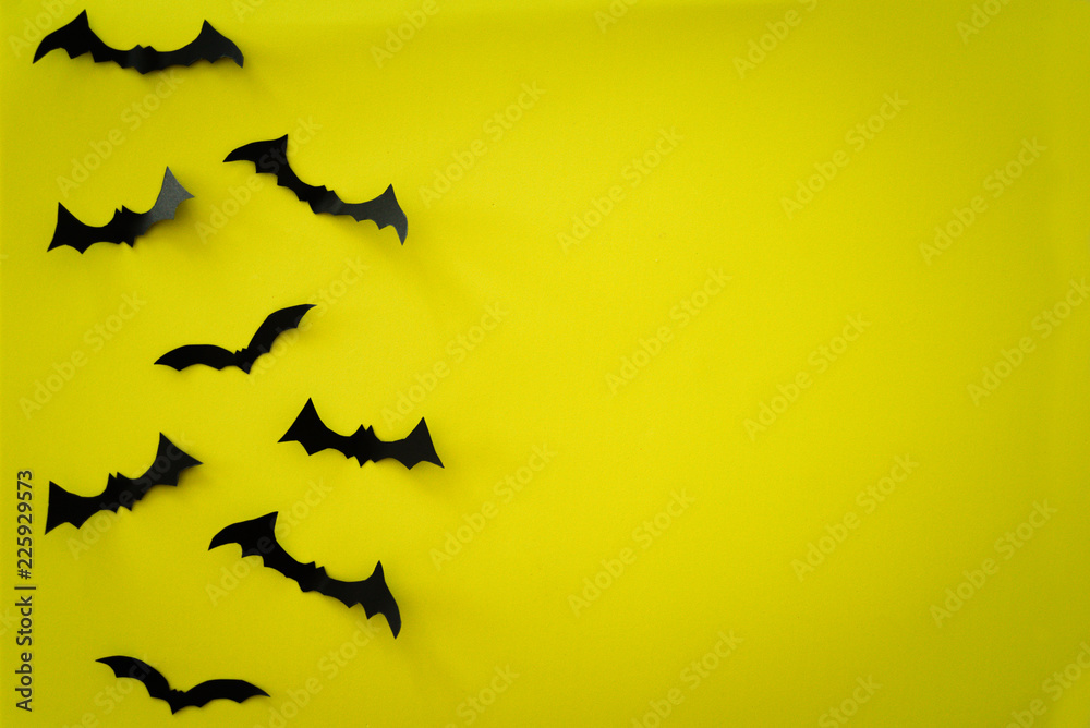 Flying bats on yellow background