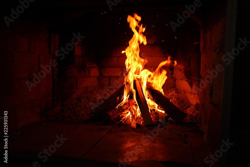 burning firewood in a brick fireplace/ fire in a brick fireplace