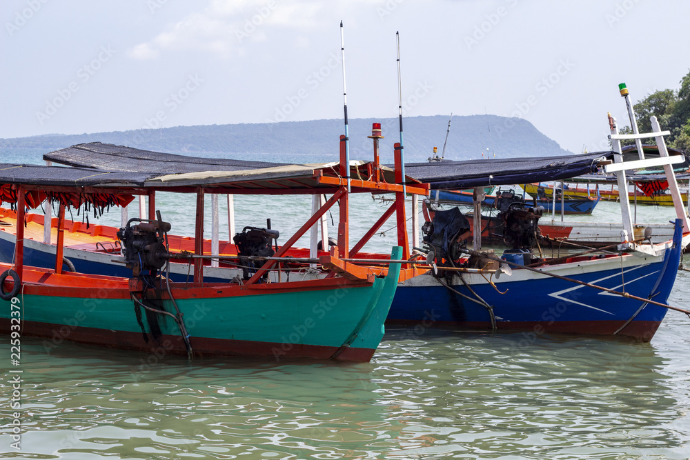 Colorful wooden boat in Cambodia. Koh Rong island seaside view with coral beach and wooden boat.