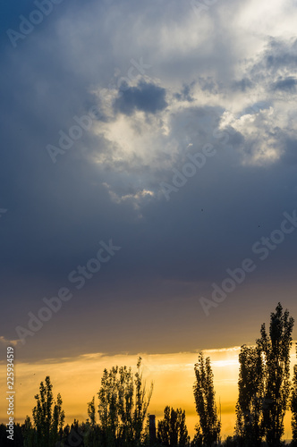 Landscape with dramatic light - beautiful golden sunset with saturated sky and clouds.