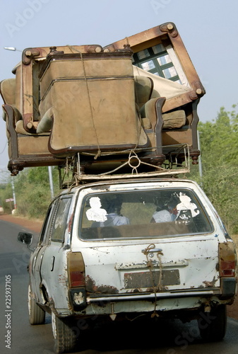 Vieille voiture et son énorme chargement improbable de fauteuils sur une route du Mali, Afrique