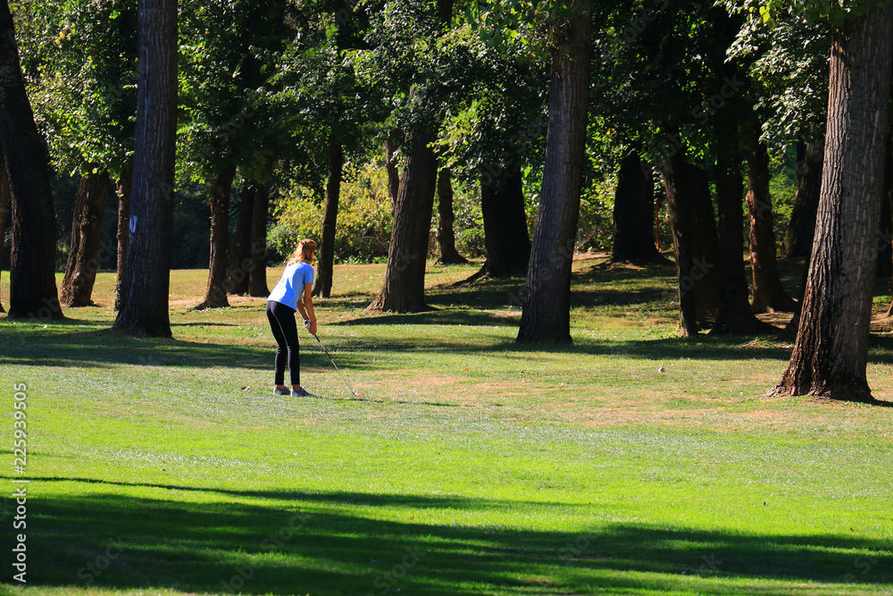 Sporty young female playing golf on the nature. Sporty young female playing golf on the nature.