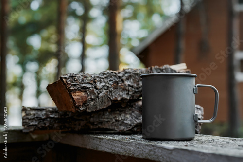 Metal mug in the nature next to the wood