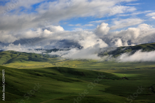 Hongyuan Grassland in Aba Prefecture, Sichuan Province, China. Near Ruoergai Grassland. Mountains, Clouds, Fields of green grass. One of the most beautiful wetland areas in China. Nomadic Lifestyle photo