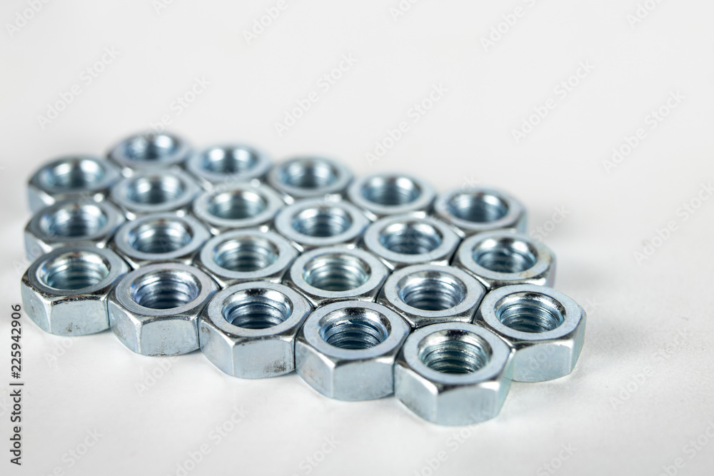 Chrome caps on a white table. Accessories for mounting steel structures on a workshop table. Chrome caps on a white table. Accessories for mounting steel structures on a workshop table.