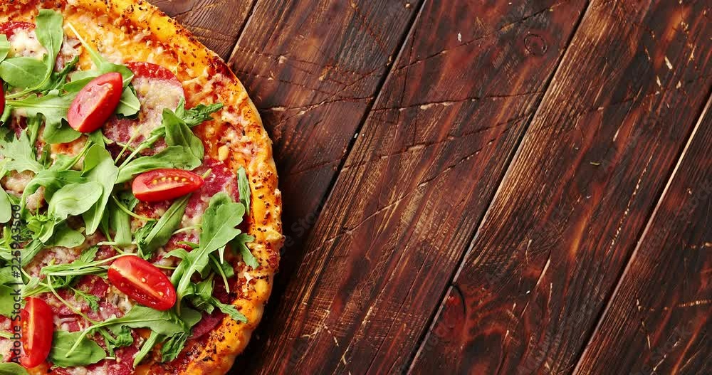 Top view of delicious italian pizza served on dark brown wooden table with copy space Top view of delicious italian pizza served on dark brown wooden table with copy space