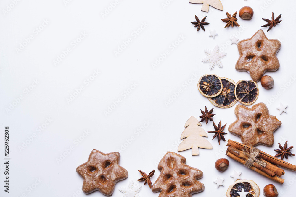 Christmas background with homemade gingerbread cookies and aromatic spices on white table. Festive food, New Year celebration traditions Christmas background with homemade gingerbread cookies and aromatic spices on white table. Festive food, New Year celebration traditions