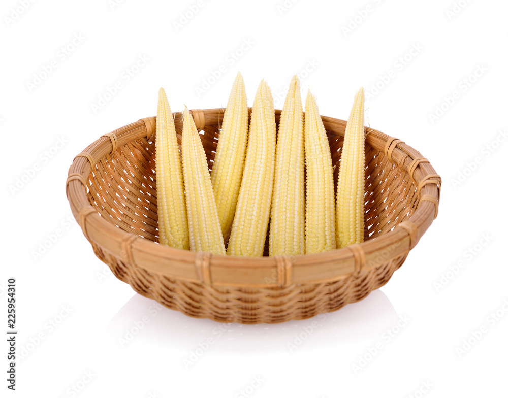 uncooked baby corns in bamboo basket on white background