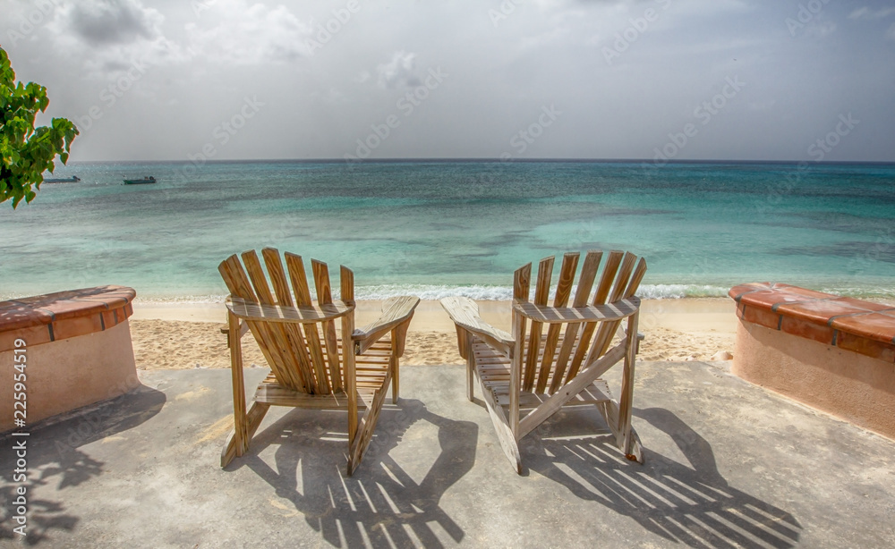 Two chairs on the beach overlooking the ocean