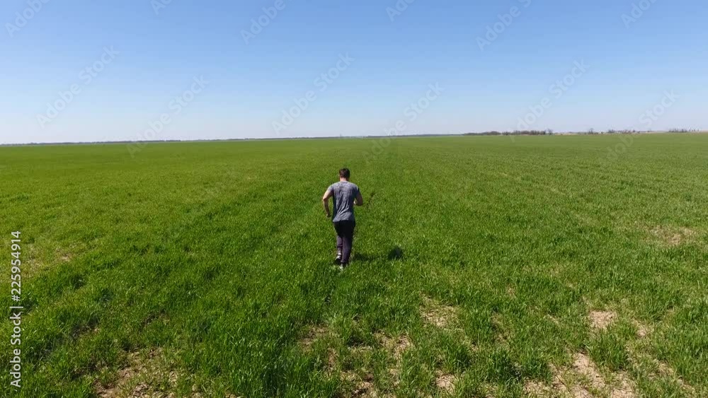 A man running through the field. Jogging in the fresh air A man running through the field. Jogging in the fresh air