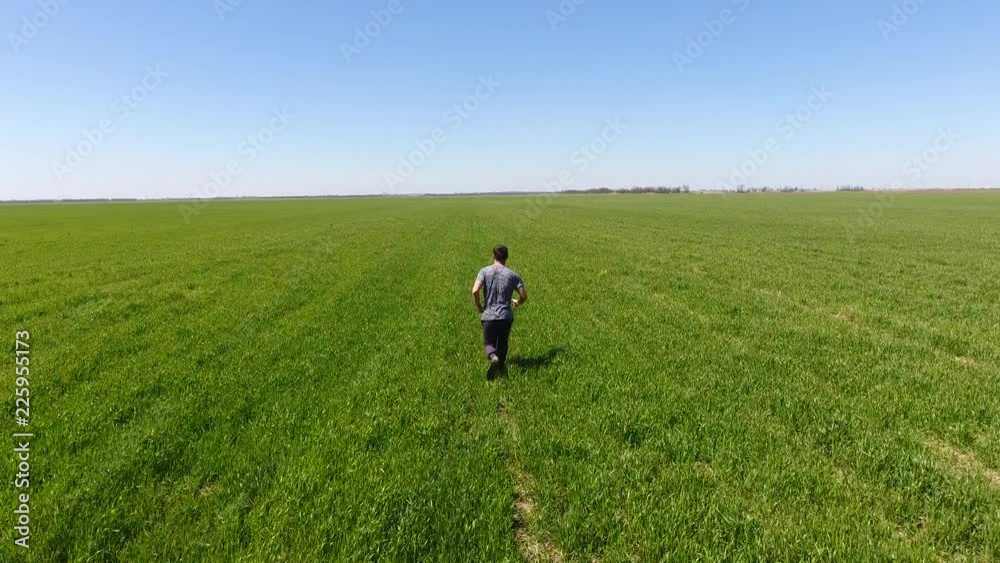 A man running through the field. Jogging in the fresh air A man running through the field. Jogging in the fresh air