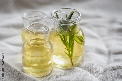6767964 Rosemary essential oil in small bottles with a fresh rosemary inside closeup