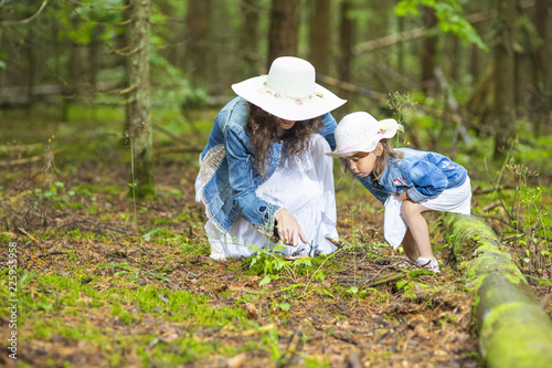 Portrait of Young Caucasian Mother with Her Daughter Playing Together in Green Summer Forest Outdoors