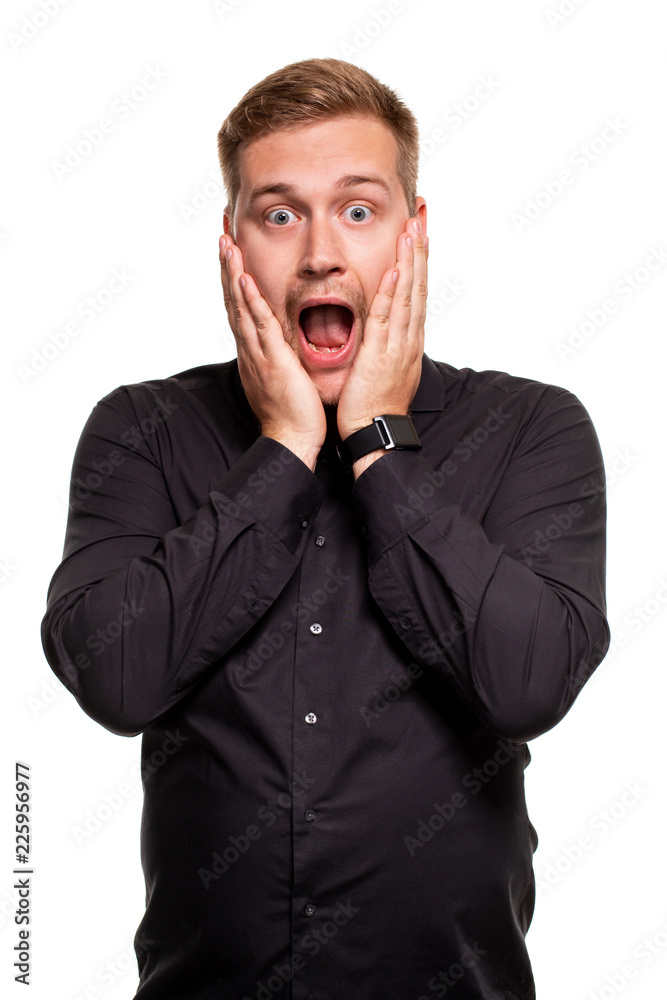 Vertical shot of stupefied stunned shocked young male keeps mouth widely opened, being surprised and very emotional, expresses great surprisment. Vertical shot of stupefied stunned shocked young male keeps mouth widely opened, being surprised and very emotional, expresses great surprisment.