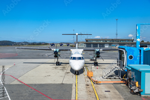 An aircraft twin turboprop parked next to a jetway at Bergen International Airport, Norway. photo