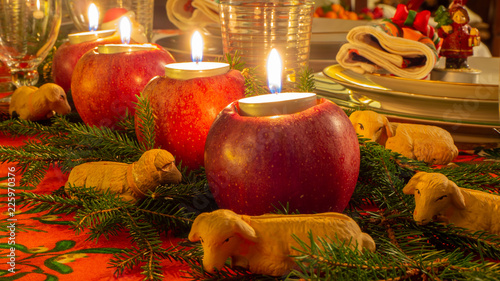 Christmas table with sheeps, red apples and candles