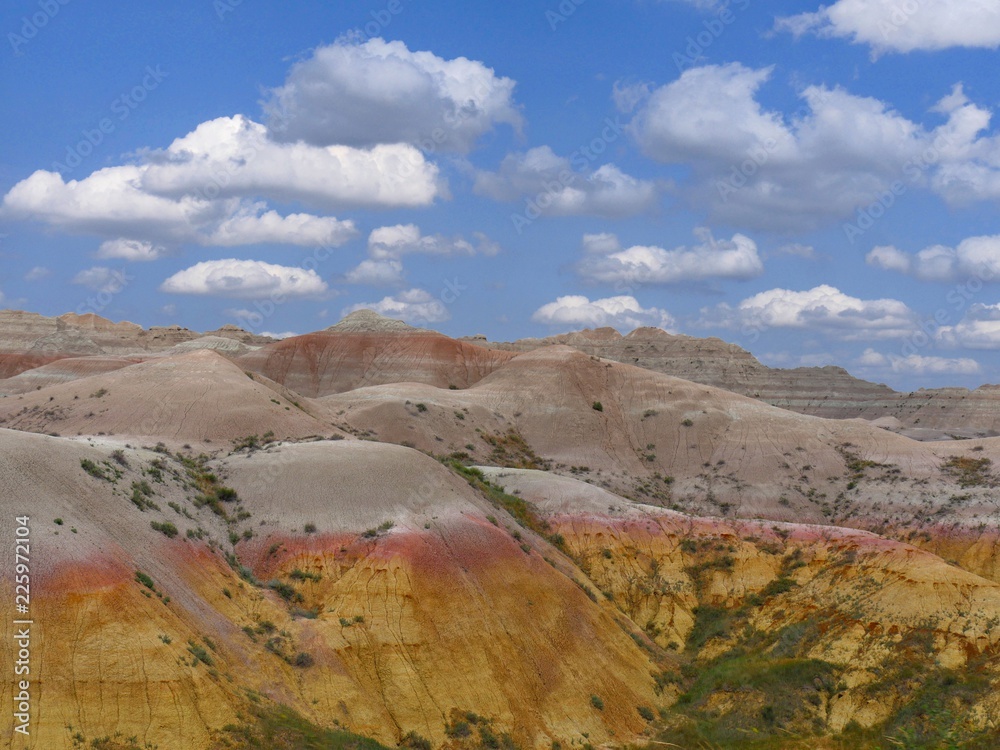 Closeup of colorful rock formations with gorgeous clouds above at Badlands National Park in South Dakota, USA.
