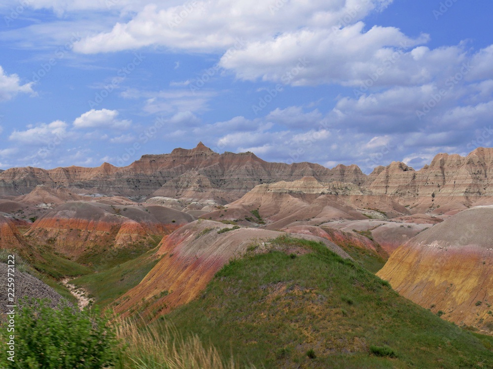 Breathtaking scene of colorful rock formations and landscape with gorgeous clouds at Badlands National Park in South Dakota, USA.