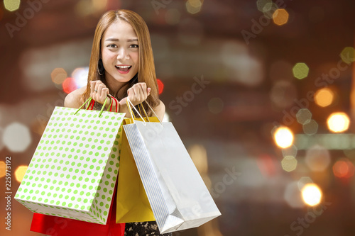 Cheerful asian girl with many shopping bags