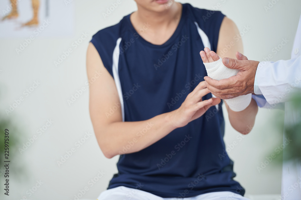 Patient asking doctor to change bandage on his wrist