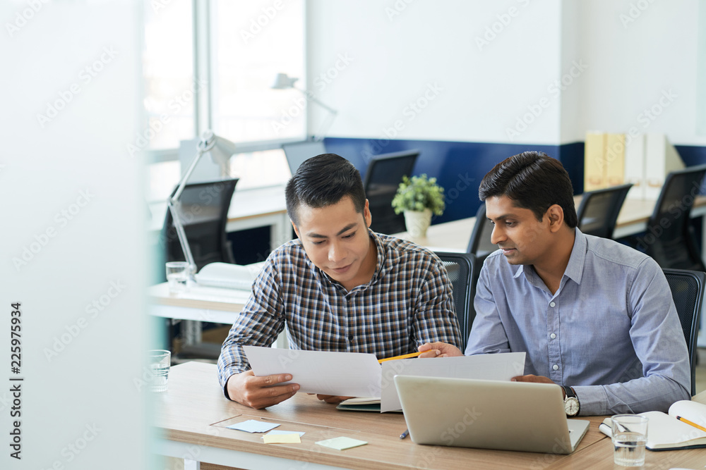 Indian businessman showing document with his project ideas Indian businessman showing document with his project ideas