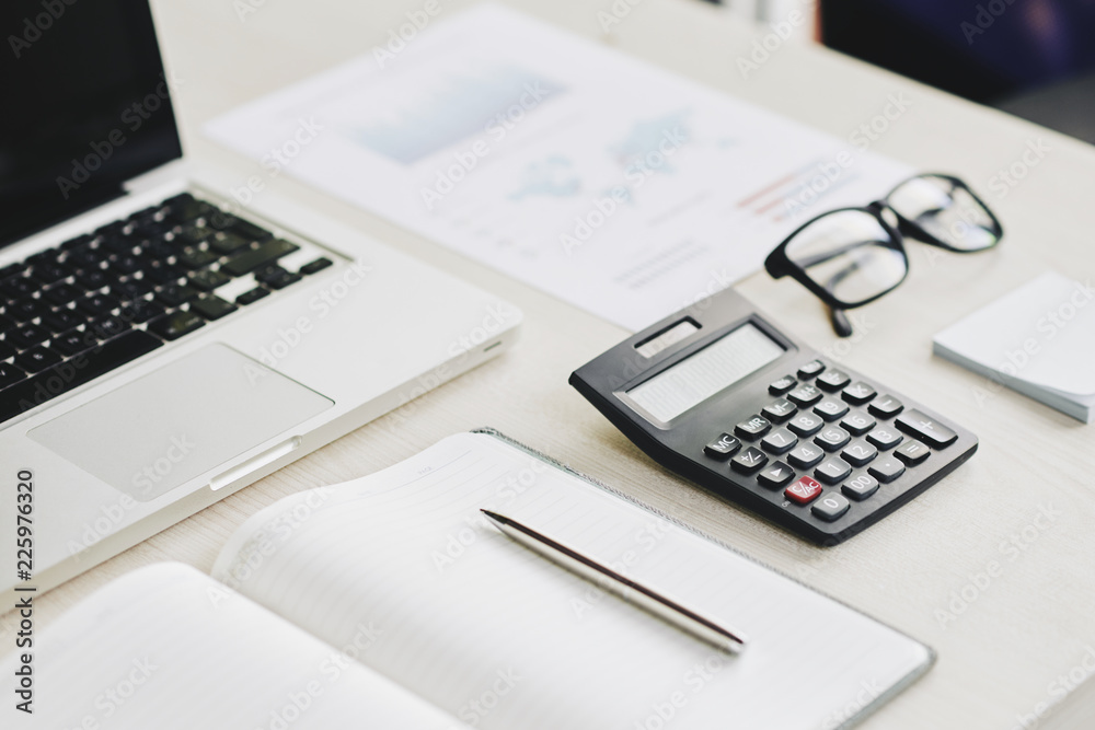 Calculator, opened notepad and glasses on table on entrepreneur Calculator, opened notepad and glasses on table on entrepreneur