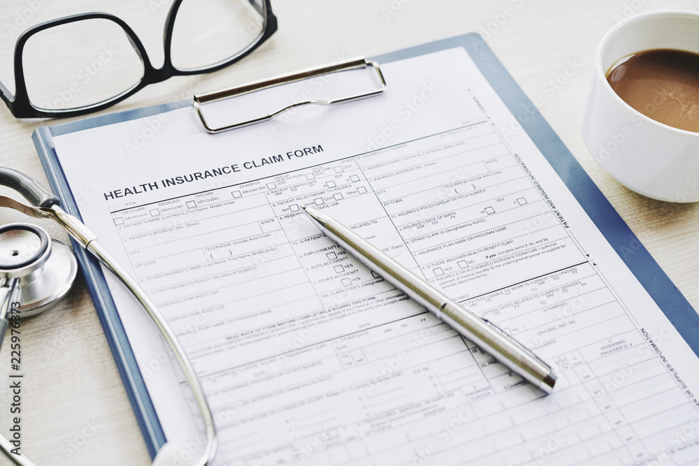 Health insurance claim form with pen and cup of coffee Health insurance claim form with pen and cup of coffee
