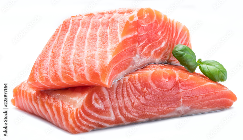 Fresh raw salmon fillets decorated with green basil. Fresh raw salmon fillets decorated with green basil.
