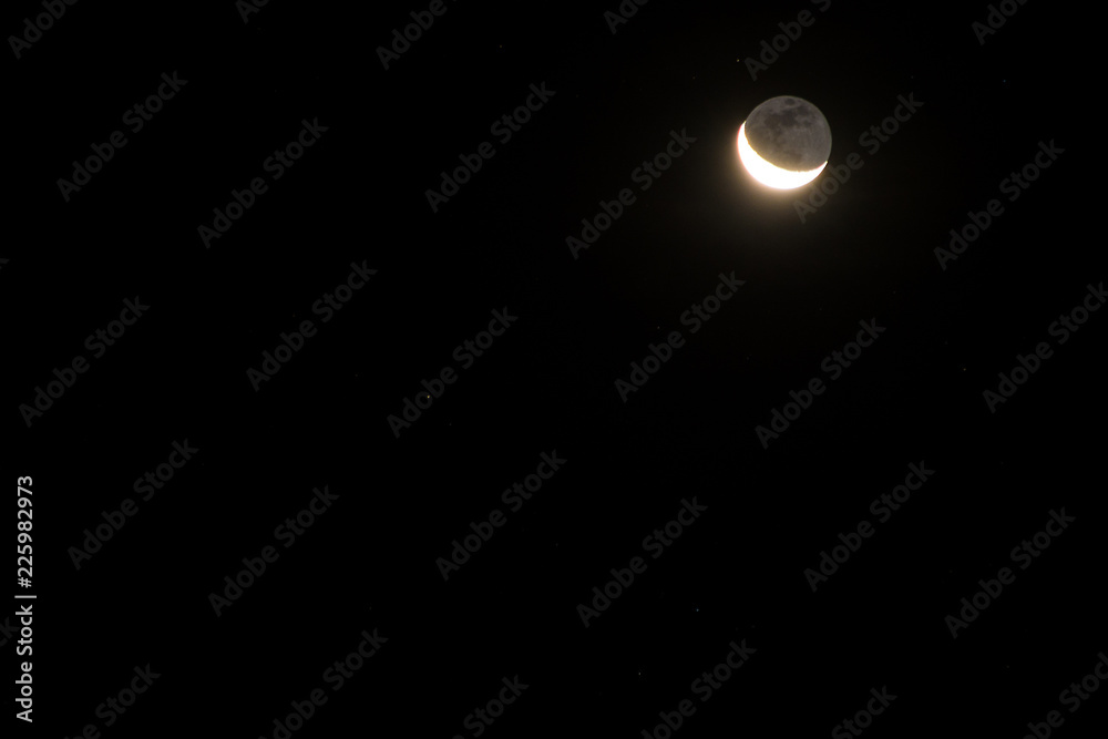 Waning moon rising early in the morning with stars surrounding it Waning moon rising early in the morning with stars surrounding it