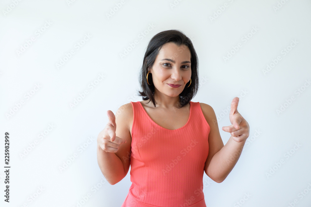 Positive attractive Caucasian woman smiling and pointing at you with index fingers. Pretty middle aged woman gesturing and looking at camera. Targeting onlooker concept. Positive attractive Caucasian woman smiling and pointing at you with index fingers. Pretty middle aged woman gesturing and looking at camera. Targeting onlooker concept.