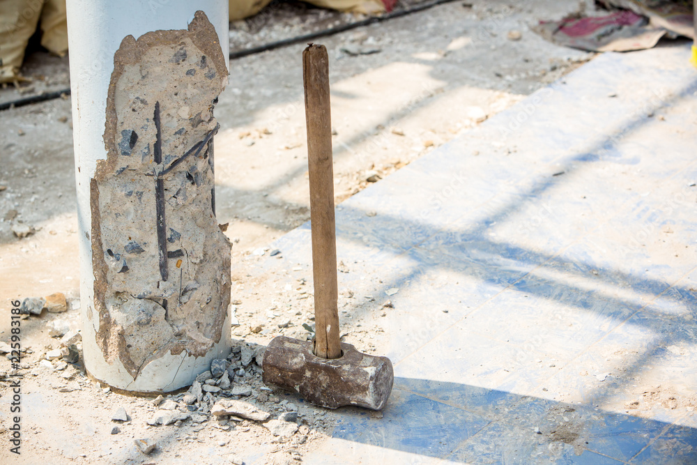 Worker holding hammer and smash to concrete pile in construction site for renovate old house. Renovation and maintenance the property is concept Worker holding hammer and smash to concrete pile in construction site for renovate old house. Renovation and maintenance the property is concept