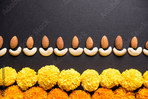Diwali diya concept using Cachew/Kaju and Almond/Badam aoing with oil lamp and flowers photo