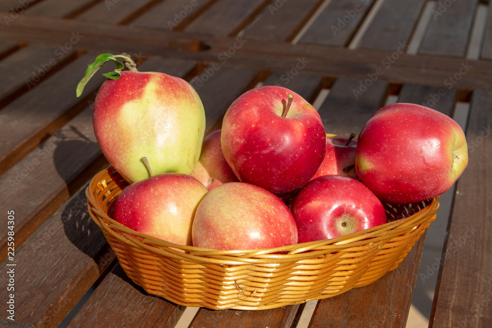 red apples in a basket on a wooden table red apples in a basket on a wooden table