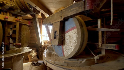 Wide-angle view working mechanism inside old-fashioned windmill. Big millstones grinding wheat into flour.Zaanse Schans, Netherlands