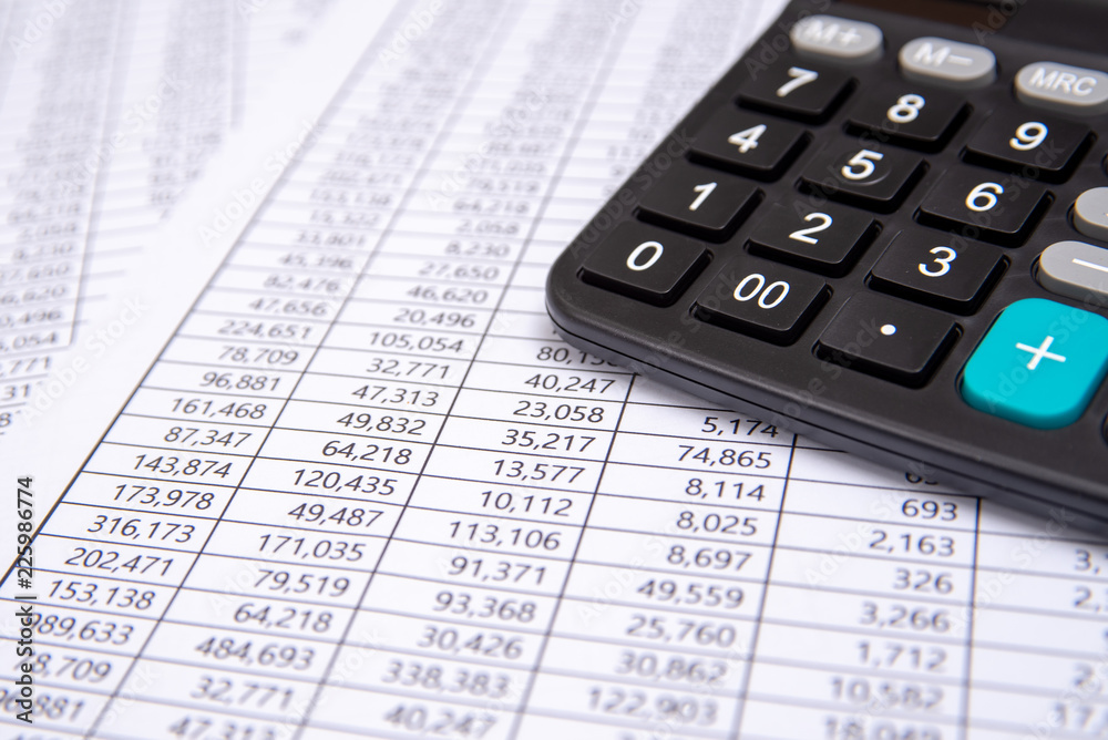 A calculator on financial chart, business concept. A calculator on financial chart, business concept.