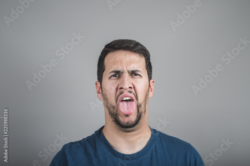 young man with disgusting face sticking out his tongue
