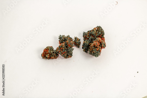 A small pile of vibrant marijuana buds infront of a white background.