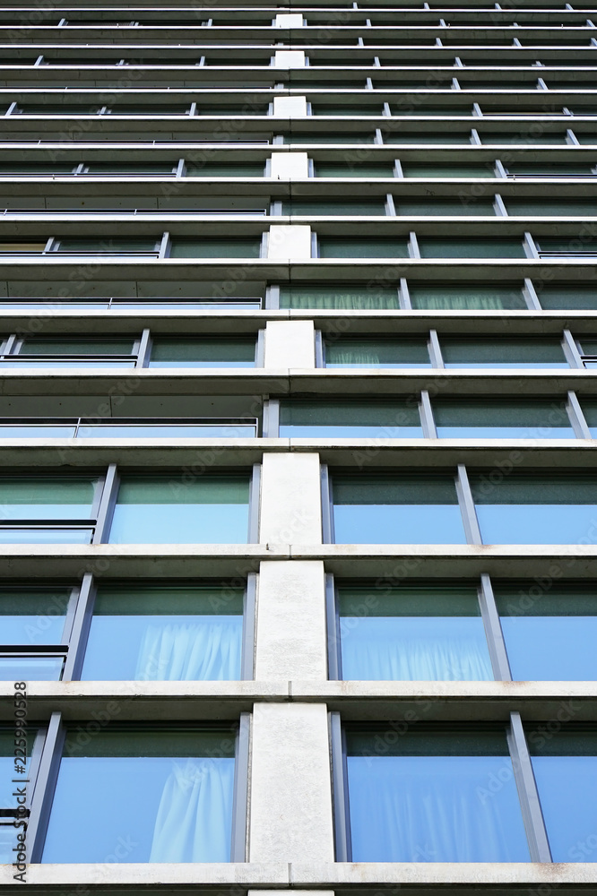 Bottom view glass grey square Windows of modern city business building skyscraper. Receding perspective, movement forward and up. Bottom view of office building window close up.