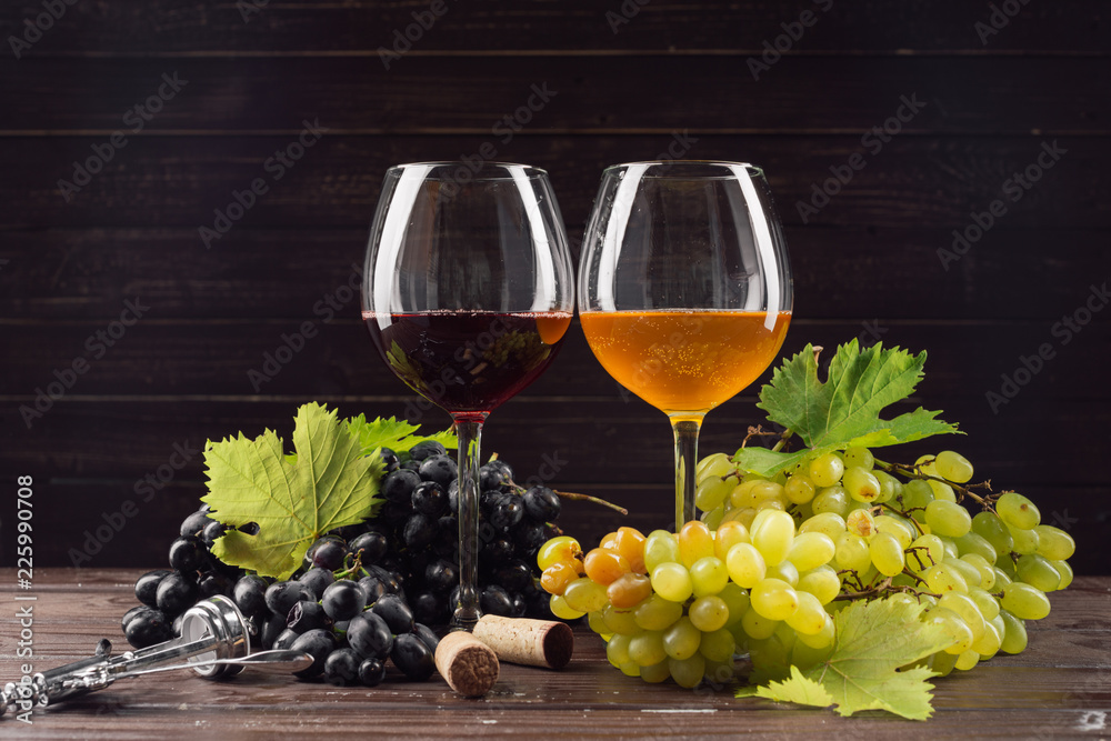 wine glass and bunch of grapes on wooden table