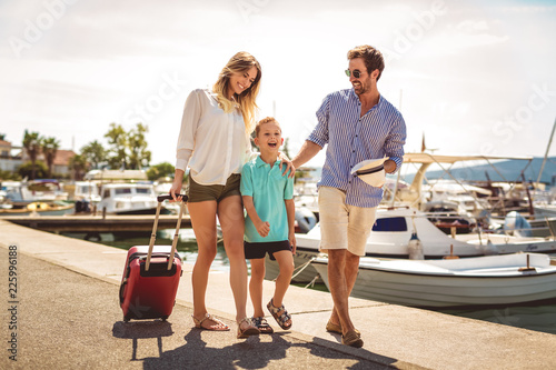 Happy family having fun, enjoying the summer time by the sea.