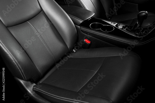 Modern Luxury car inside. Interior of prestige car. Comfortable leather seats. Black perforated leather cockpit with stitching. Steering wheel and dashboard. Automatic gear stick shift. Car detailing © Aleksei