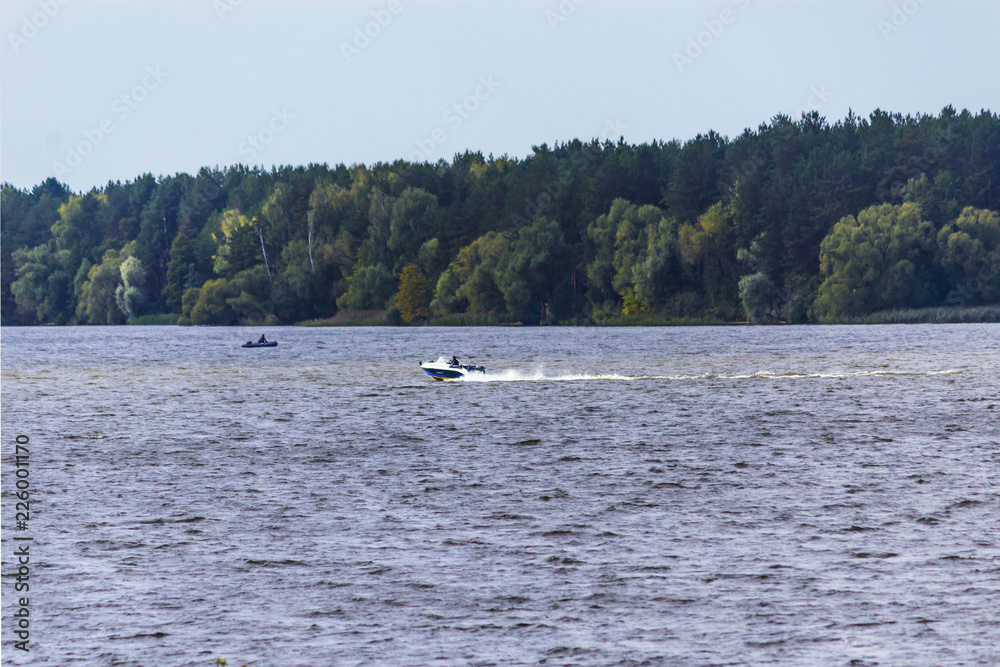 Early autumn.The Volga River near Konakovo.A motor boat with a fisherman.Tver Region, Central Russia.Background for the site about travel and fishing.