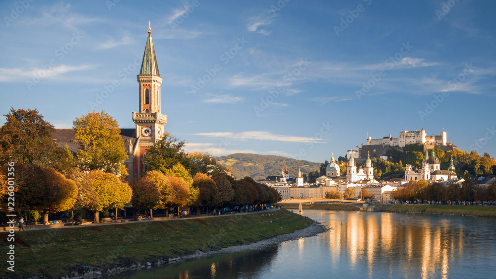 Fototapeta premium Salzburg w jesiennym wieczornym słońcu, widok na kościół Chrystusa z Makartsteg, twierdzę Hohensalzburg, katedrę, stare miasto