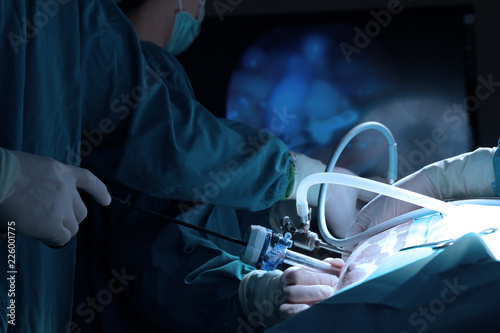 Veterinarian doctor in operation room for laparoscopic surgical take with art lighting and blue filter photo